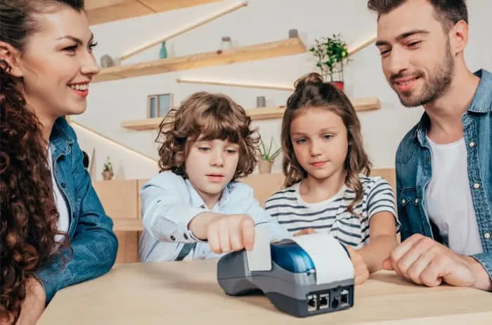 parents with 2 children looking at calculator
